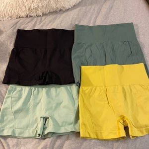 4 pairs of shein spandex shorts in mint, dark green, black, and yellow